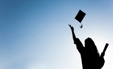 Graduate throws cap in air celebrating her MBA