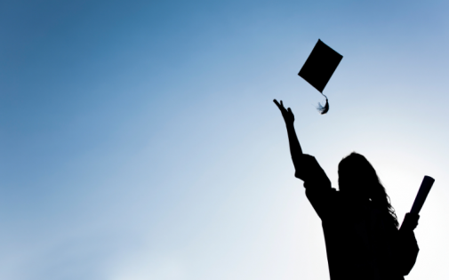 Graduate throws cap in air celebrating her MBA